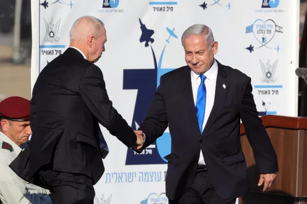 Netanyahu, 29 Haziran'da Beerşeba'daki Hatzerim Hava Üssü'ndeki pilotların mezuniyet töreninde Savunma Bakanı Yoav Gallant ile tokalaşırken (EPA)