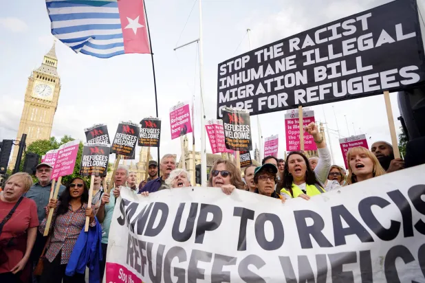 يتظاهرون ضد قانون الهجرة غير الشرعية بساحة البرلمان في وستمنستر الاثنين (د.ب.أ)