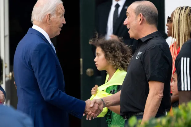 الرئيس الأميركي جو بايدن يحيي مفوض الدوري قبل مباراة (كل النجوم) في الحديقة الجنوبية للبيت الأبيض (أ.ف.ب)