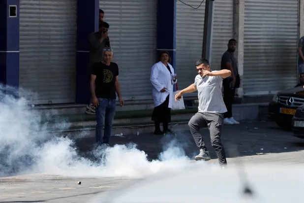 رجل يتفاعل مع الغاز المسيل للدموع خلال هجوم إسرائيلي بعد إطلاق نار على مفرق تقوع في الضفة 16 يوليو (رويترز)