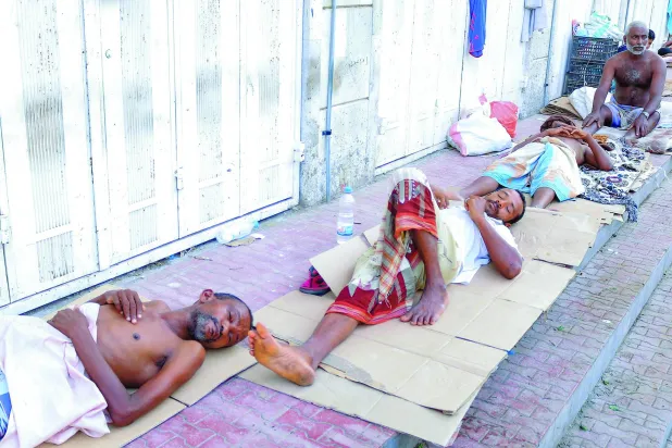 
يمنيون ينامون على أحد أرصفة الحديدة من شدة الحر داخل المنازل (أ.ف.ب)