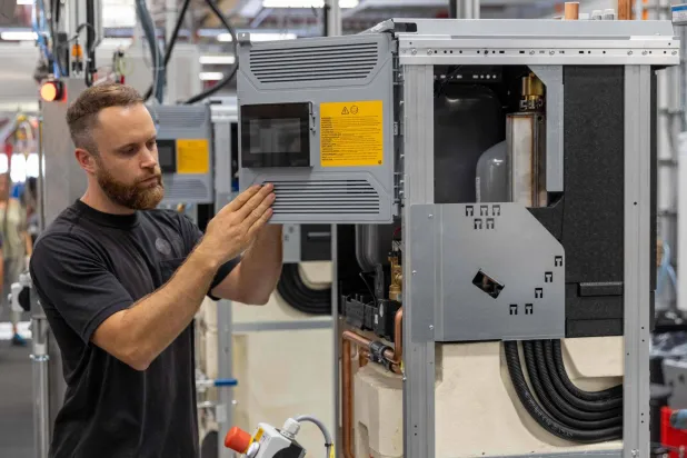 عامل يقوم ببناء الوحدة الداخلية لمضخة حرارية في مصنع «بوش هوم كمفورت غروب» في إيبلسهاوزن غرب ألمانيا (أ.ف.ب)
