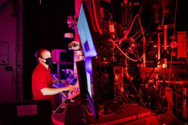 الباحث ريان شويل في أثناء استخدام المجهر الإلكتروني (الكريديت: كريج فريتز - مختبرات سانديا الوطنية)