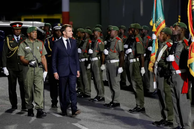 ماكرون يستعرض حرس الشرف في مطار بور فيلا عاصمة جمهورية فانواتو الأربعاء (أ.ف.ب)