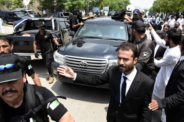 أفراد الأمن يرافقون السيارة التي كانت تقل رئيس الوزراء الباكستاني السابق عمران خان عند وصولها للمثول أمام المحكمة العليا في إسلام آباد بباكستان في 26 يوليو 2023 (إ.ب.أ)