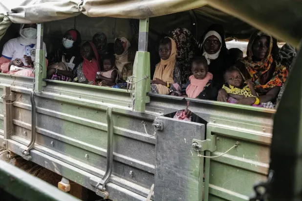 Displaced people from el-Geneina in Darfur on a French army truck en route to temporary shelters on the outskirts of Adre, Chad (Reuters)