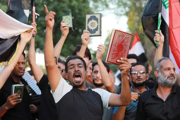 عراقيون يشاركون في مظاهرة تندد بحرق المصحف الشريف في السويد بمنطقة الجادرية بالقرب من «المنطقة الخضراء» ببغداد السبت الماضي (أ.ف.ب)