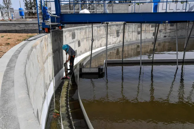 مهندس يقوم بتنظيف جنبات محطة سليانة لمعالجة مياه الصرف الصحي (أ.ف.ب)