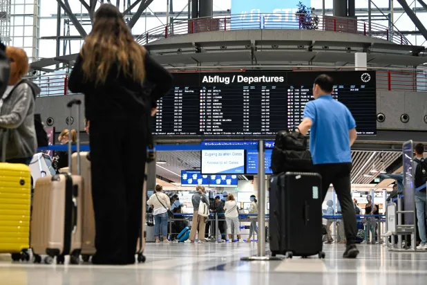 مسافرون في مطار شتوتغارت الألماني يتأهبون للمغادرة فيما تزداد التوقعات الاقتصادية قتامة (ا ف ب)