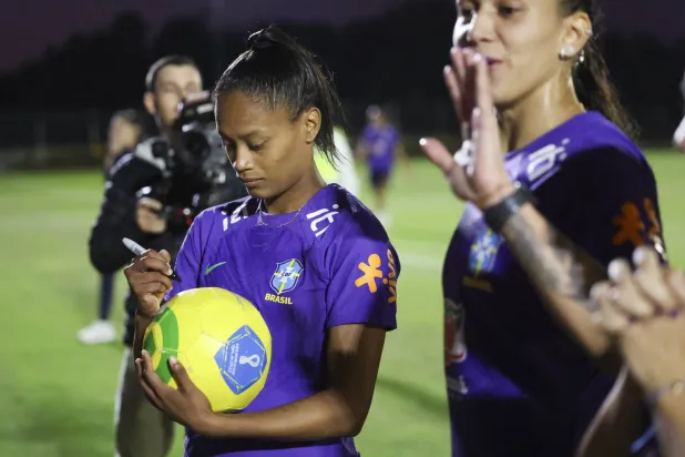 البرازيلية آري بورغيس توقع على كرة تخص لاعبي كابولتشر الرياضي في مجمع موريتون (أ.ب)