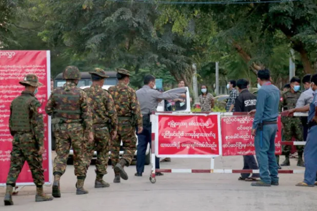 قوات أمن أمام مدخل بيت ضيافة ينزل به نواب في برلمان ميانمار بالعاصمة (إ.ب.أ)