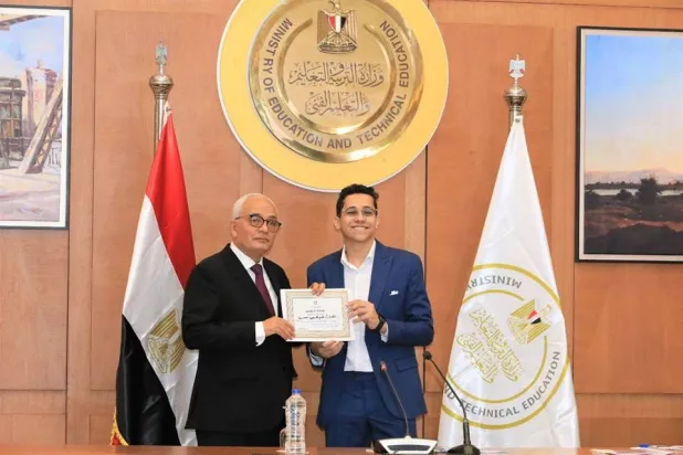الدكتور رضا حجازي لدى تكريمه أحد الطلاب الأوائل في الثانوية العامة (وزارة التربية والتعليم المصرية)