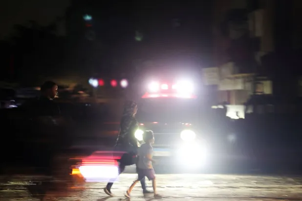 أسرة مصرية تعبر طريقاً مظلماً وسط العاصمة القاهرة جراء انقطاع التيار الكهربائي... وهي الأزمة التي لا تزال مستمرة رغم تراجع حدتها (رويترز)