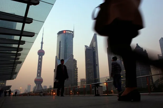 صينيون يمشون على جسر بمقاطعة شنغهاي الصينية... وسط مؤشرات على تراجع قوي للصادرات (رويترز)