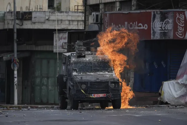 Nablus’ta meydana gelen önceki çatışmalarda İsrail askerlerine ait bir zırhlı araç yakıldı (AP)