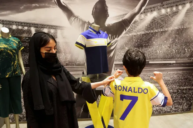 طفل يرتدي قميص رونالدو في أحد المتاجر الخاصة بالنادي في الرياض (رويترز)
