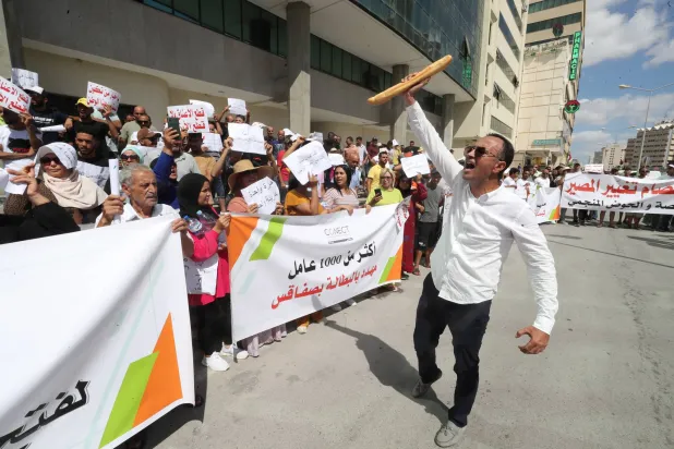 مظاهرة نظمها بعض سكان العاصمة أمام وزارة التجارة للاحتجاج على نقص الدقيق والخبز (إ.ب.أ)