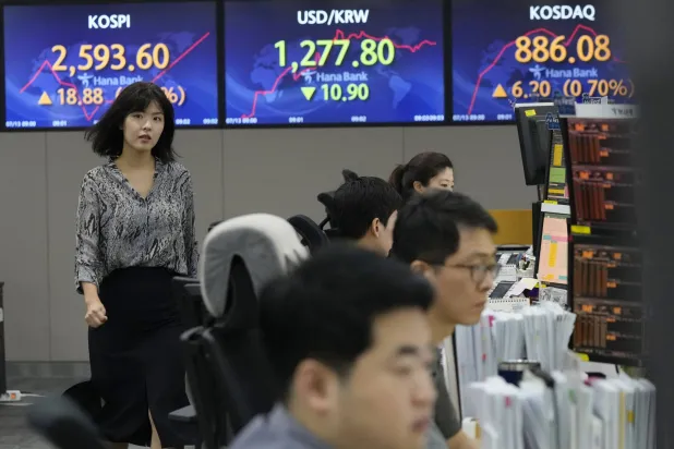 مديرو حسابات في غرفة تداول تعرض مؤشر أسعار الأسهم الكورية (أعلى اليسار) وسعر صرف الدولار (الوسط) في سيول (أ.ب)