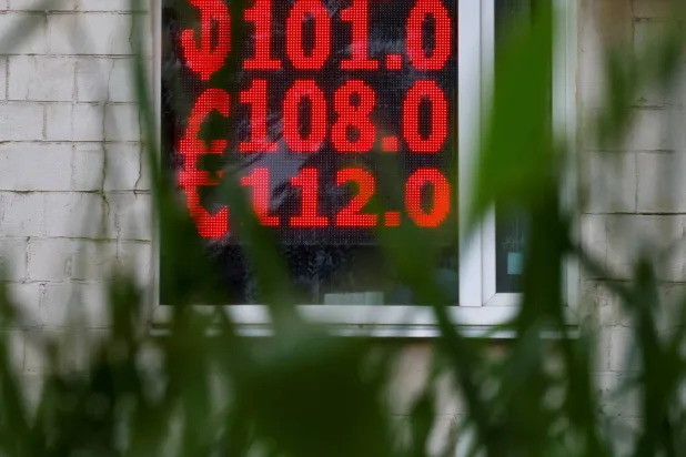 شاشة إلكترونية تظهر تجاوز الدولار حاجز 100 روبل في العاصمة الروسية موسكو صباح الاثنين (رويترز)