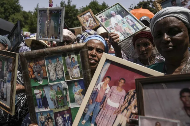 إسرائيليون من أصل إثيوبي يحملون صوراً لأقاربهم خلال مظاهرة أمام مكتب رئيس الوزراء في القدس الأحد  (أ.ب)