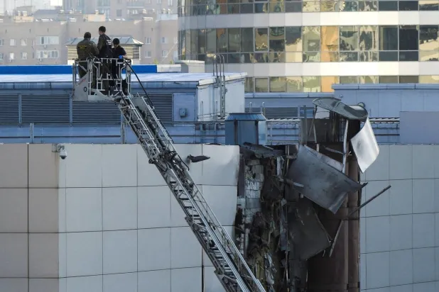 Görevliler, Ukrayna’ya ait SİHA’nın Moskova’da düşürülmesinin ardından hasar gören çatının yakınında çalışıyor (Reuters)