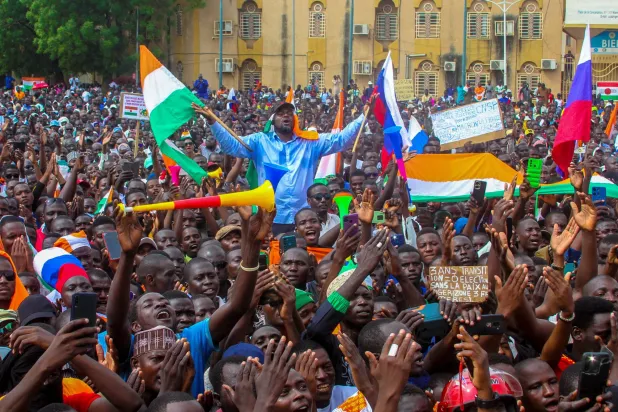 أنصار المجلس العسكري يحملون أعلام النيجر وروسيا في نيامي الأحد (رويترز)