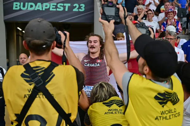 الكندي إيثان كاتزبرغ محاطاً بالمصورين عقب فوزه بذهبية الإطاحة بالمطرقة (أ.ف.ب)