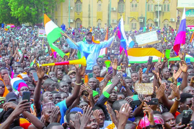 فوجی کونسل کے حامی اتوار کے روز نیامی میں نائیجر اور روس کے جھنڈے اٹھائے ہوئے ہیں (رائٹرز)
