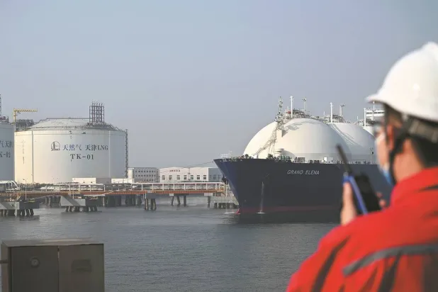 موظف في شركة سينوبك الصينية يساعد في إرساء ناقلة غاز طبيعي مسال في تيانجين (من «تويتر»)