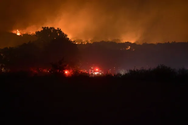 رجال الإطفاء يعملون أثناء حريق هائل في قرية موناستيراكي بالقرب من مدينة ألكسندروبوليس، تراقيا، شمال اليونان (إ.ب.أ)