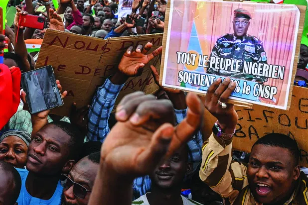 
مؤيدون للانقلاب العسكري في النيجر يحملون صورة الجنرال تياني في نيامي الأحد (أ.ف.ب)