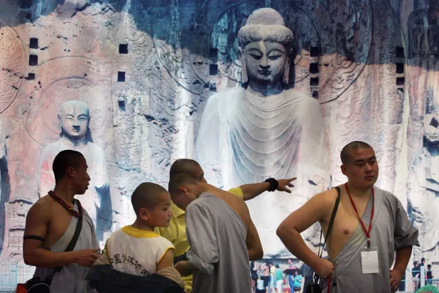 رهبان من معبد «شاو لين» الصيني يستعدون لتقديم عرض في «معرض السفر عبر مضيق تايبيه» خلال «معرض تايبيه الدولي للسفر» في 3 نوفمبر 2006 (رويترز)