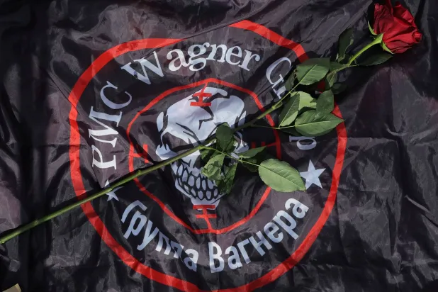 وردة على علم يحمل شعار «فاغنر» في نصب تذكاري بالقرب من مركز المجموعة السابق في سان بطرسبرغ (رويترز)