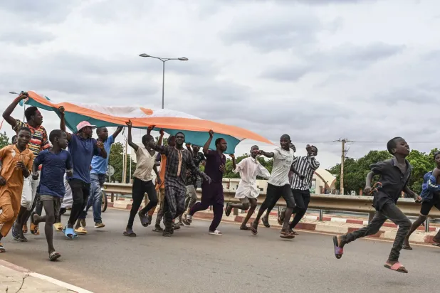 أنصار للمجلس العسكري في النيجر يتجمعون في العاصمة نيامي في 11 أغسطس 2023 قرب قاعدة جوية فرنسية (أ.ف.ب)