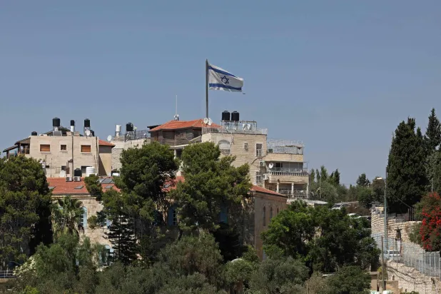 علم إسرائيلي فوق مبنى في حي عربي بالقدس الشرقية الجمعة (أ.ف.ب)