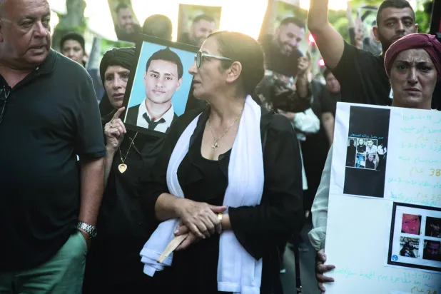 
عائلات ضحايا الجريمة في المجتمع العربي الإسرائيلي يرفعون صورهم خلال احتجاج على ارتفاع معدلات الجريمة 6 أغسطس (غيتي)