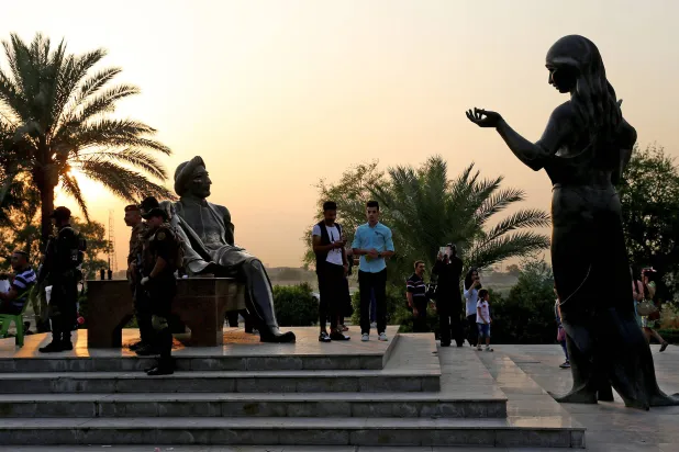 عراقی سیکورٹی فورسز اور زائرین دارالحکومت بغداد میں دریائے دجلہ کے قریب ابو نواس اسٹریٹ پر مجسموں کے پاس کھڑے ہیں (آرکائیوز - گیتی)