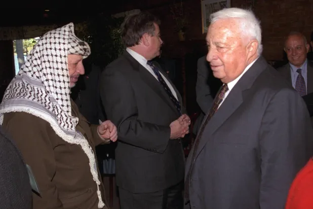 لقاء بين عرفات وشارون خلال مفاوضات في أميركا عام 1998 (غيتي)