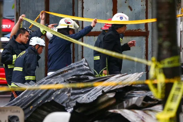 رجال الإطفاء يتفقدون مكان اندلاع الحريق في منزل يتألف من طابقين تم تحويله إلى مصنع للملابس في الفلبين (وسائل إعلام محلية)