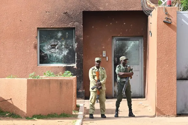 شرطيان أمام مدخل السفارة الفرنسية في نيامي الأثنين الماضي (أ. ف. ب)