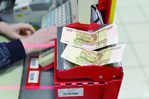 أوراق نقدية من فئة 100 روبل أمام عامل في أحد المتاجر في منطقة سيبيريا شمال روسيا (رويترز)