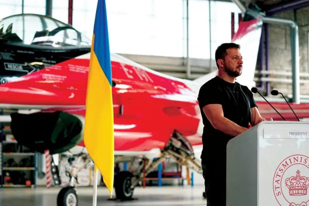 Başkan Zelenskiy, F-16 savaş uçaklarının önünde konuşuyorken (AFP)