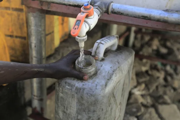 الحصول على المياه النظيفة مهمة صعبة في اليمن... أهالي صنعاء يحصلون على ماء صالح للشرب من أحد الأنابيب الموصولة بخزان (إ.ب.أ)