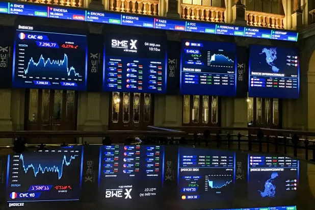 شاشات تعرض حركة الأسهم على مؤشر «إيبكس 35» في بورصة العاصمة الإسبانية مدريد (إ.ب.أ)