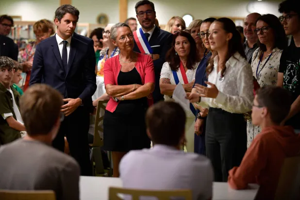 وزير التعليم والشباب الفرنسي غابريال أتال (يسار) يقف مع رئيسة الوزراء الفرنسية إليزابيث بورن أثناء حديثهما للشباب خلال زيارتهم لمدرسة سيمون فيل الثانوية في اليوم الأول من العام الدراسي في ليفري (أ.ف.ب)