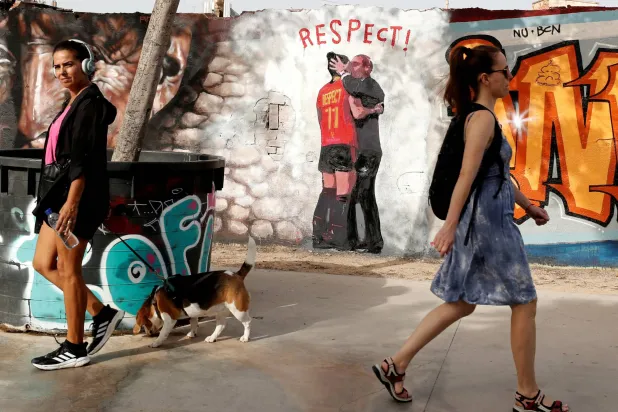 رسومات على الجدارن لقُبلة روبياليس للاعبة الإسبانية وسط المارة (رويترز)