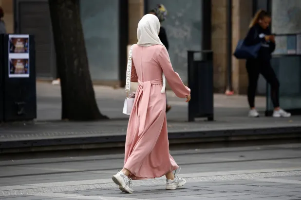 امرأة مسلمة ترتدي العباءة تسير في أحد شوارع مدينة نانت بفرنسا في 29 أغسطس 2023 (رويترز)