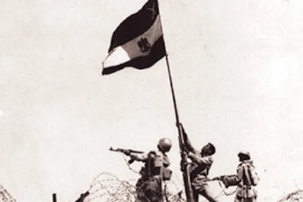 المجند المصري محمد عبد السلام العباسي لدى رفعه العلم المصري على خط بارليف في حرب أكتوبر عام 1973 (الشرق الأوسط)