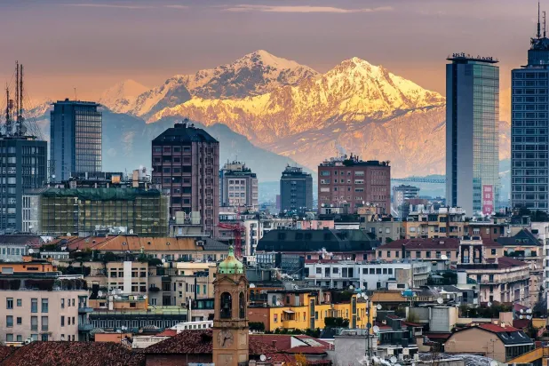 منطقة أعمال وبنوك في مدينة ميلانو مع جبال الألب في الخلفية (غيتي)