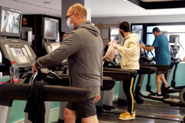 رجال يمارسون الرياضة في نادٍ رياضي بإسبانيا (إ.ب.أ)